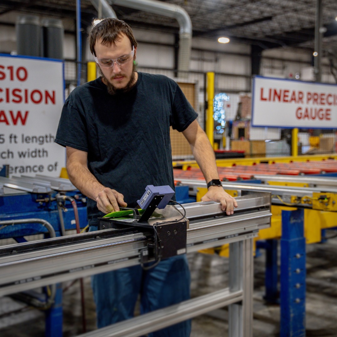 Machinist measuring an aluminum component against a precision gauge